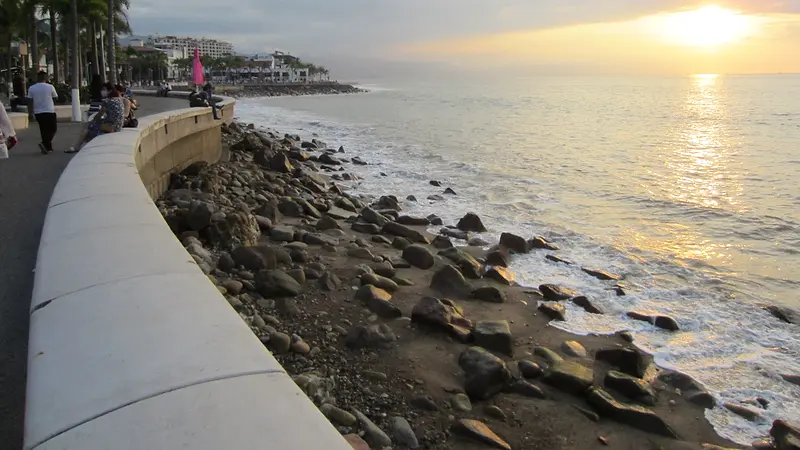 Atardecer sobre la bahía desde el malecón de Puerto Vallarta, con palmeras