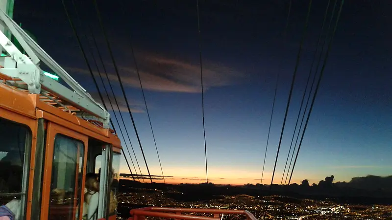 Cabina del teleférico de Monserrate al atardecer, con Bogotá iluminada abajo